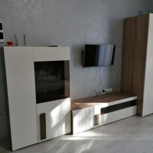 a white entertainment center with a tv on a wall at КарпатиКайзервальд. in Karpaty