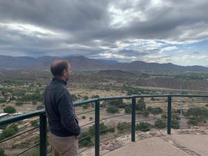 un hombre parado en un balcón con vistas a un valle en “Viví Mendoza” en Mendoza