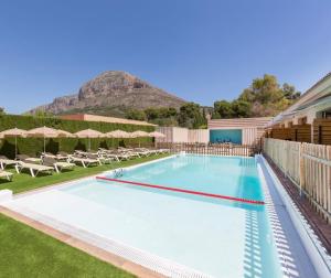 a swimming pool with a mountain in the background at Hotel Fortuny javea in Jávea