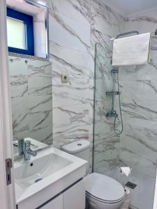 a white bathroom with a sink and a toilet at Imperial Douro Apartamento 7 in Peso da Régua