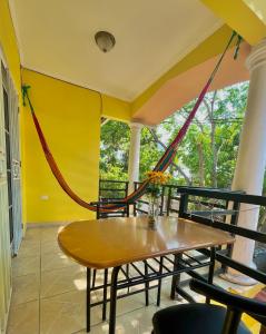 a porch with a table and chairs and a hammock at Mango Hostel in Comayagua