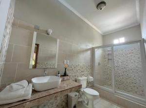 Baño blanco con lavabo y aseo en Mango Hostel, en Comayagua