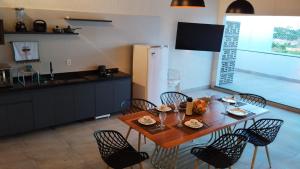 a kitchen with a wooden table with chairs and a table and a dining room at JUAZEIRO TEMPORADAS in Juazeiro do Norte