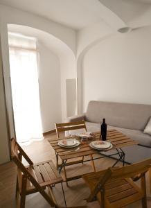 ein Wohnzimmer mit einem Tisch und einem Sofa in der Unterkunft Il Vicoletto sul Mare in Ischia