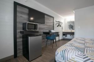 een slaapkamer met een bed en een bureau met een televisie bij Motel 6 Pico Rivera - Los Angeles, CA in Pico Rivera