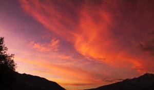 a sunset in the sky over a mountain at Almawasi Lodge in Yungay