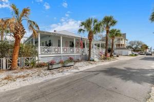 ein weißes Haus mit Palmen davor in der Unterkunft Big Mama Beach House Limited time 5BDR, POOL in Tybee Island