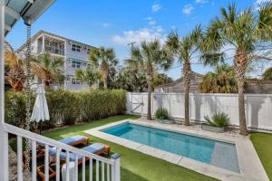 einen Hinterhof mit einem Pool und Palmen in der Unterkunft Big Mama Beach House Limited time 5BDR, POOL in Tybee Island