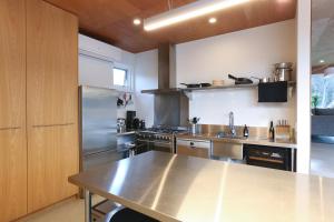 a large kitchen with a stainless steel counter top at Rye Glass House - Architectural Escape in Rye