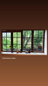una ventana en una habitación con vistas a los árboles en Almawasi Lodge, en Yungay