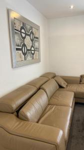 a brown leather couch in a living room with a picture at Oran Harouni bouziane in Oran