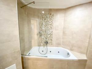 a bath tub in a bathroom with a shower at Oran Harouni bouziane in Oran