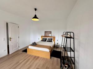 Un dormitorio con una cama y una escalera. en Casa da Mãe Ju, en Porto de Mós