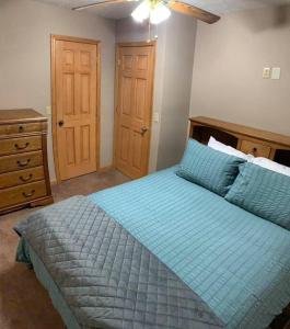 una camera con letto blu e cassettiera di Summersville Lake Rd Cabin - Pet Friendly! a Mount Nebo