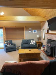 un soggiorno con divano e tavolo di Summersville Lake Rd Cabin - Pet Friendly! a Mount Nebo