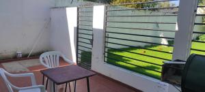 balcón con mesa, sillas y ventana en casa con garaje rejas y camaras a 24 minutos del aeropuerto Ezeiza Amplio parque para mascotas en Ezeiza