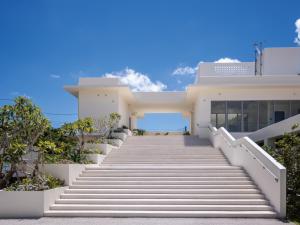 a staircase leading up to a house with blue sky at Private condo Kourijima by Coldio Smart Resort in Nakijin