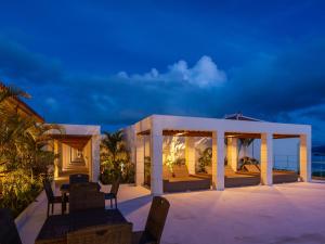 eine Terrasse mit Stühlen und einem Pavillon in der Nacht in der Unterkunft Private condo Kourijima by Coldio Smart Resort in Nakijin