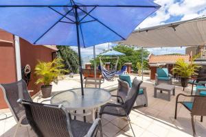 a table and chairs with a blue umbrella on a patio at Renovated condo in Tamarindo, 3 min from the beach in Tamarindo