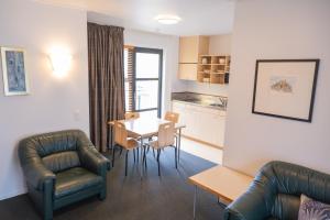 a living room with a table and chairs and a kitchen at Victoria Court Motor Lodge - Free Parking in Wellington