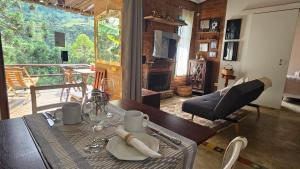 a dining room with a table and a view of a balcony at Chalé LuNê Vista para a Montanha , Banheira Imersão Externa e Lareira in Gonçalves