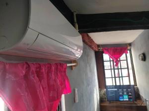 Habitación con cortinas rosas y ventana en Hermosa Habitación La Estancia, en Tamasopo