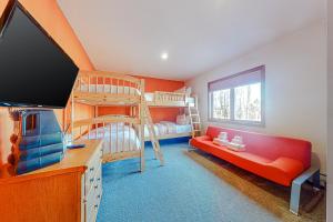 a living room with a red couch and bunk beds at Alpine Abode in Dover