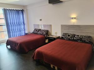 um quarto de hotel com duas camas e uma janela em HOTEL PLATINIUM em La Paz