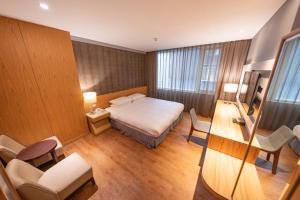 台北市にある雲富大飯店 Hotel Cloud-ZhongShanのベッドと机と椅子があるホテルの部屋