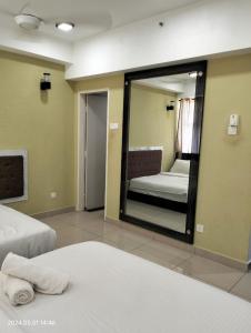 a large mirror in a room with a bed and a bedroom at Nuha Studio Stay at D'perdana Apartment in Kota Bharu