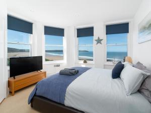 a bedroom with a bed and a flat screen tv at 1 Little Beach in Woolacombe