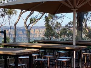 a group of tables with chairs and an umbrella at Selby Cottage in Katoomba
