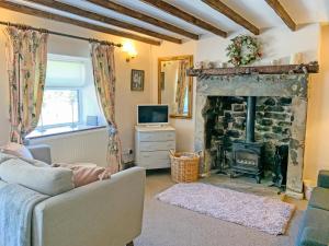 a living room with a couch and a fireplace at Golf Cottage in Chinley