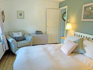 a bedroom with a bed and a chair in it at Golf Cottage in Chinley