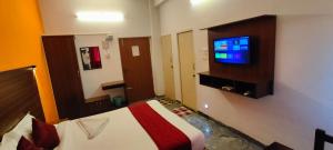 a hotel room with a bed and a flat screen tv at Hotel New Cresent park in Coimbatore