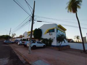 a house with cars parked in a parking lot at Hotel Indi Suíte Quádruplo in Ribeirão Preto