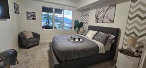 ein Schlafzimmer mit einem Bett und einem Stuhl in der Unterkunft Lake View Beach, Marina, Pool, HT in Kelowna