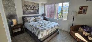 1 dormitorio con cama, sofá y ventana en Lake View Beach, Marina, Pool, HT en Kelowna