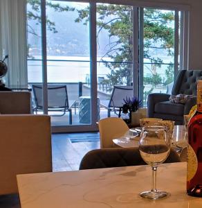 Lake View Beach, Marina, Pool, HT في كيلونا: طاولة مع كأس نبيذ يجلس عليها