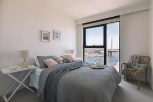 1 dormitorio con cama, mesa y ventana en Premier Harbour View & Parking near Marvel Stadium, en Melbourne