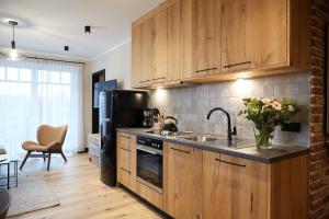 eine Küche mit Holzschränken und einem schwarzen Kühlschrank in der Unterkunft Binnendiek Haus 1 Apartment 8 in Büsum