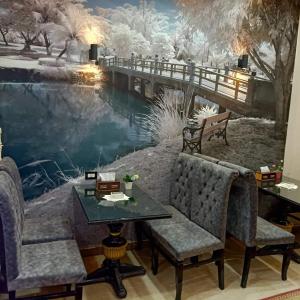 ソハーグにあるDahab hotelの冬の壁画の前にテーブルと椅子が備わる客室です。