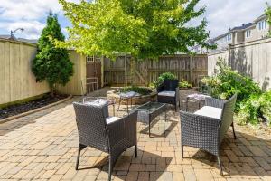 un patio con sillas, mesas y una valla en Modern Cozy 4BR Home with Sunny Patio, en Ottawa