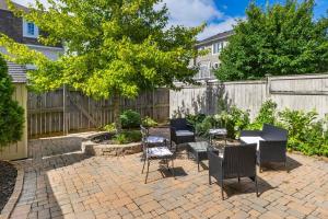 eine Terrasse mit Stühlen, Tischen und einem Zaun in der Unterkunft Modern Cozy 4BR Home with Sunny Patio in Ottawa