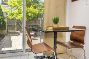 Modern Cozy 4BR Home with Sunny Patio في أوتاوا: طاولة وكرسيين أمام النافذة