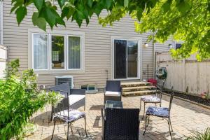 eine Terrasse mit Stühlen und einem Tisch vor einem Haus in der Unterkunft Modern Cozy 4BR Home with Sunny Patio in Ottawa