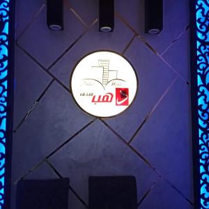 um sinal numa mesa roxa com duas cadeiras em Dahab hotel em Sūhāj