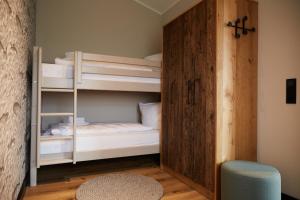 ein Zimmer mit zwei Etagenbetten mit einer Holztür in der Unterkunft Binnendiek Haus 2 Apartment 11 in Büsum + 21 Fotos
