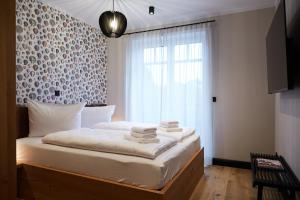 ein Schlafzimmer mit einem Bett mit weißer Bettwäsche und einem Fenster in der Unterkunft Binnendiek Haus 4 Apartment 8 in Büsum + 20 Fotos