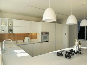 een keuken met witte kasten en een aanrechtblad bij Kelly's House in Medellín +7 foto's